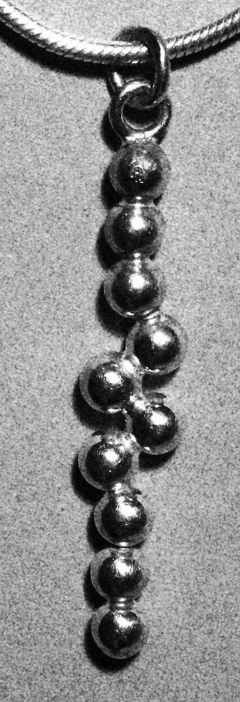 Jewellery based on the buckled line of spheres problem.